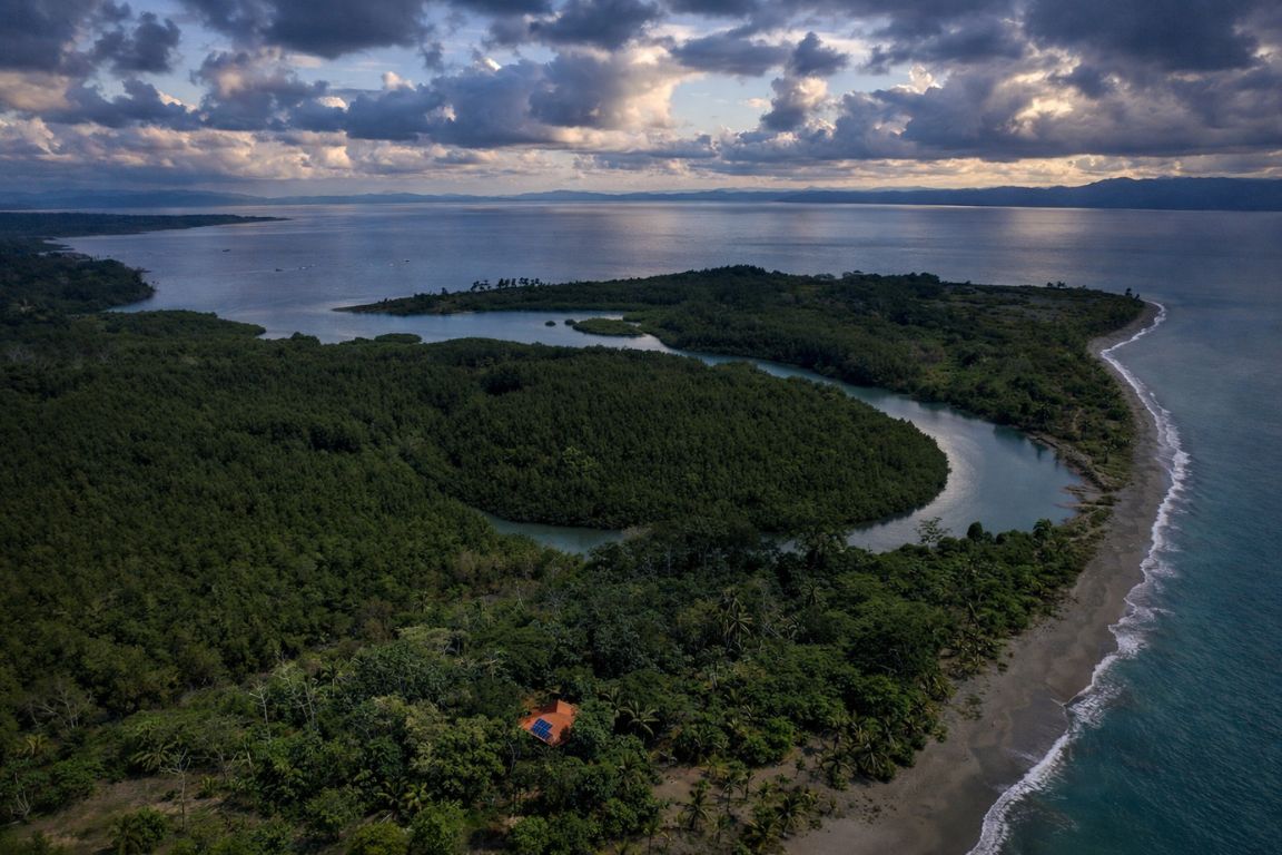 Scenic aerial of Puerto Jiménez in Costa Rica with tropical forest, shoreline, and calm waters, seen during a guided tour with Corcovado National Park Tours